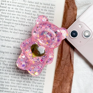 Dettaglio del supporto per telefono a forma di orso rosa con glitter e cuore dorato