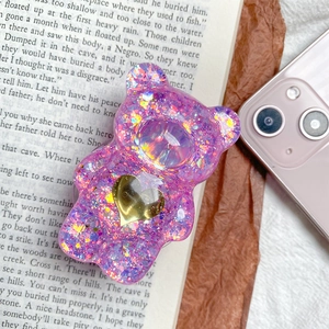 Dettaglio del supporto per telefono a forma di orso glitter viola con cuore oro