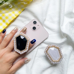 Close-up of pearl and gemstone phone grip holder on an iPhone for a luxury look