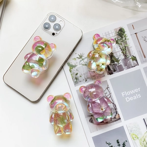 Detail view of bear-shaped holographic phone grip with real dried flowers and leaves