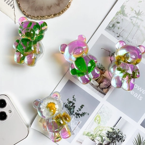 Detail of bear-shaped holographic phone grip with real dried flowers and resin