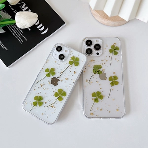 Dettaglio custodia iPhone trasparente con veri quadrifogli e decorazione in foglia d'oro