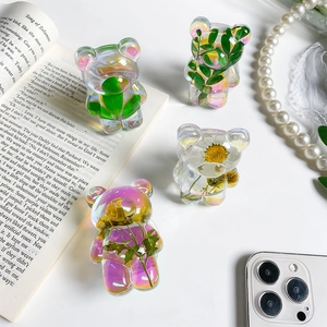 Detail of colorful resin bear phone grip with real dried flower specimens and laser finish