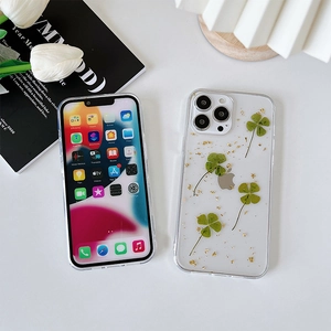 Vista dettagliata della cover iPhone trasparente con vero quadrifoglio e foglie d'oro