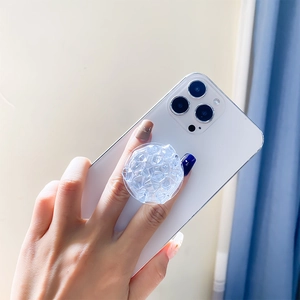Detail of transparent ice-crystal phone grip on smartphone with faceted diamond texture