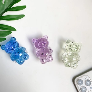 Macro detail of transparent bear phone grips with colorful glitter foil accents