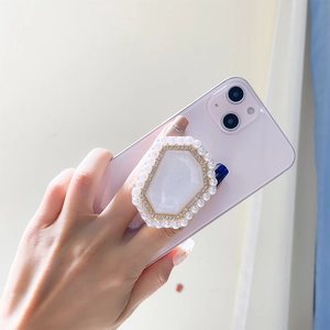 Detail of a pearl and rhinestone hexagon collapsible phone grip held in hand