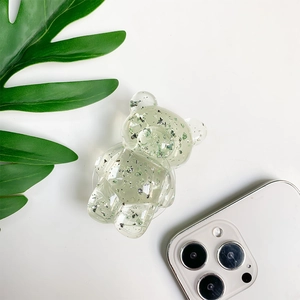 Detail of cute bear phone grip with green and silver glitter in transparent resin