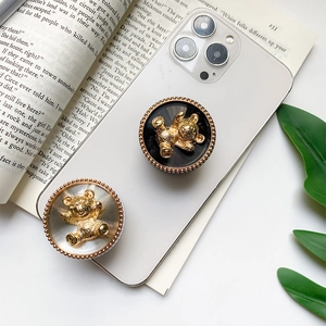 Detailed view of black and white bear phone socket grips with golden embossed accents