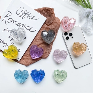 Glittery heart-shaped resin phone socket grip with colorful sequins in various colors