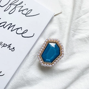 Detail of a phone socket featuring a large blue gem with pearls and rhinestones