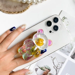 Holographic bear phone grip with yellow dried flowers embedded in clear resin