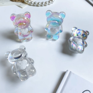 Détail de quatre supports de téléphone ours irisés avec cœurs 3D blancs sur fond blanc