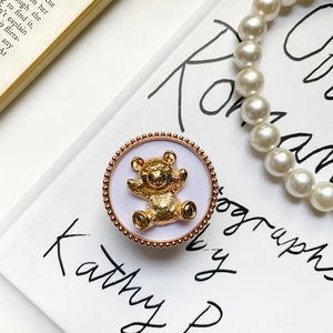 Close-up of golden bear relief on lavender base with pearl background details