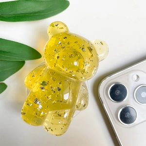 Detailed view of bear-shaped phone grip with silver foil in transparent resin