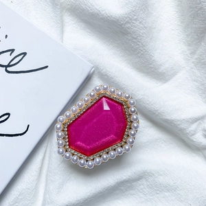 Macro shot of rose pink gemstone phone grip with sparkling rhinestones and white pearls