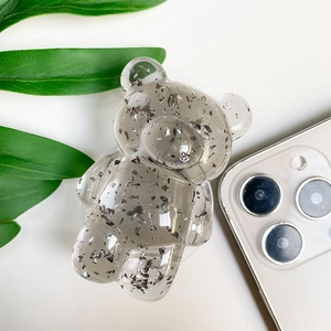 Detailed close-up of a transparent bear phone grip with sparkling silver foil inside