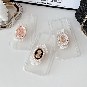 Detail of vintage Victorian cameo charms with faux pearls and roses on clear phone cases