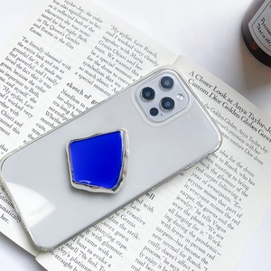 Blauer Handy-Sockel auf klarem Gehäuse mit Metallrand auf einem Modemagazin platziert