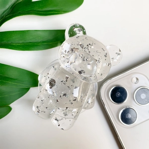 Detailed close-up of transparent bear phone grip with decorative silver foil interior