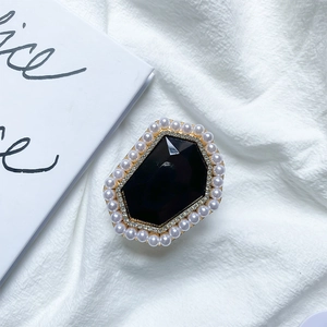 Detail of elegant pearl and rhinestone phone grip with a faceted black gemstone center