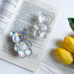 Détail du support de téléphone ours holographique et transparent sur un livre