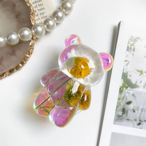 Detail view of colorful laser bear phone stand with embedded real dried flowers