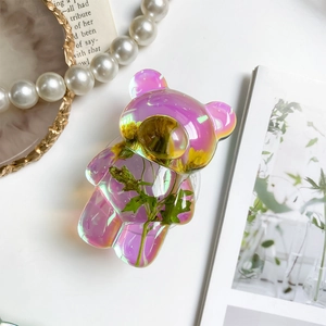 Detail of bear-shaped phone grip featuring colorful resin and embedded dried flowers