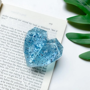 Detailed view of a blue heart-shaped resin phone socket with glitter on a book