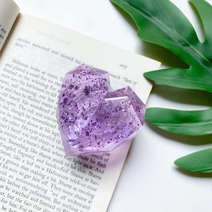 Macro detail of a purple resin heart phone socket with sparkling foil on an open book