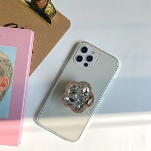 Close-up of luxury rhinestone flower phone socket on a transparent case with soft shadows