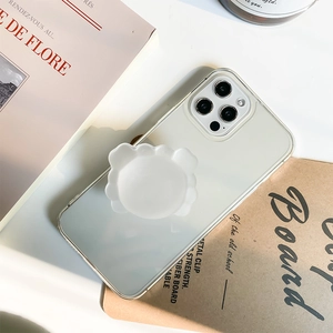 Detail of white flower-shaped pop socket on transparent mirror iPhone Pro phone case