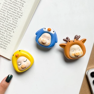 Detail of cute pig phone socket stands dressed in animal outfits on a white desk