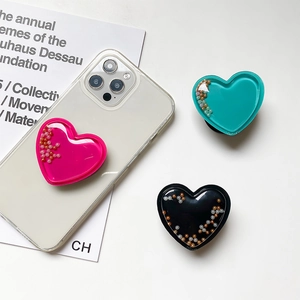 Macro shot of heart-shaped glitter phone sockets in rose, teal, and black colors