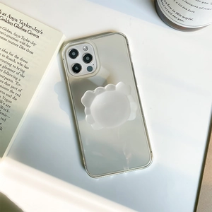 Detailed view of clear phone case with white cloud pop socket on a minimal desk