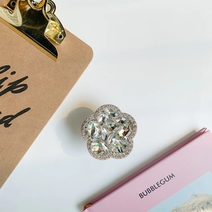 Detailed view of silver flower grip tok encrusted with rhinestones and clear crystals