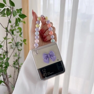 Detailed view of clear Samsung Galaxy Z Flip case with purple bow and colorful bead chain