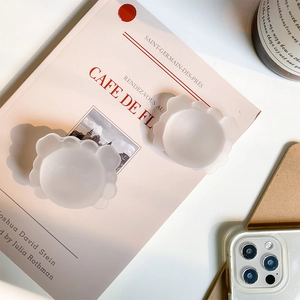 Matte white cloud-shaped jewelry trays placed on a book for modern home aesthetic