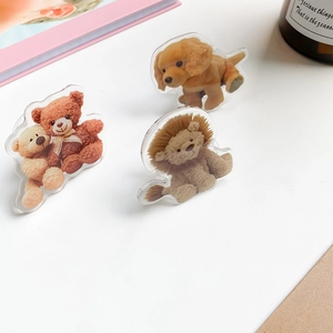 Detail shot of cute acrylic animal phone grips featuring a golden retriever and teddy bears