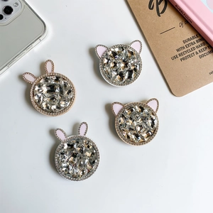 Close-up of luxury rhinestone phone grips with rabbit and cat ear accents in pink enamel