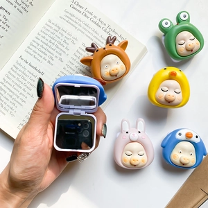 Detail of cute animal folding makeup mirror phone grip shown held in hand over magazine