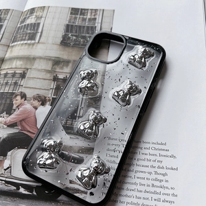 Detail of transparent iPhone case with 3D silver bears and glitter foil on a magazine