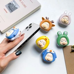 Detailed view of cute 3D cartoon animal phone grip stands on a white surface