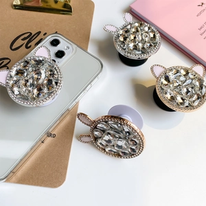 Detail of luxury rhinestone phone grip with cute rabbit ears on a smartphone