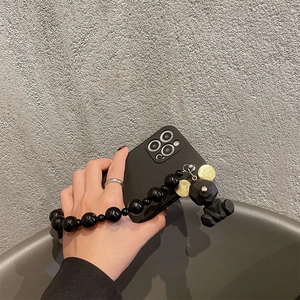 Matte black iPhone case with glossy bead wrist strap and geometric bear charm