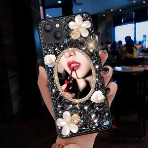 Detail of luxury iPhone case with black crystals, pearl flowers and a portrait mirror