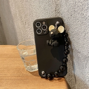 Detail of matte black iPhone case with geometric bear pendant and beaded wrist chain strap