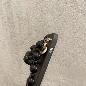 Black iPhone case with matte finish featuring a chunky black beaded wristlet strap