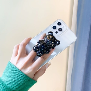 Detail of a translucent black bear grip tok with gold foil on a white phone case