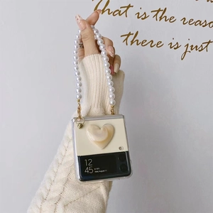 Detail of Galaxy Z Flip case featuring a 3D cream heart and detachable pearl chain handle
